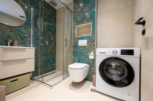 a bathroom with a washing machine and a toilet at Aurelia Residence in Metković