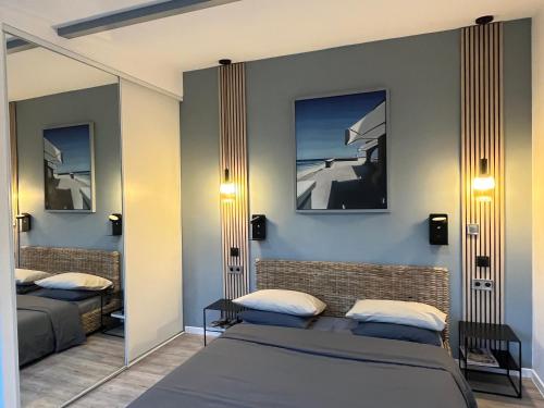 a bedroom with two beds and a mirror at Studio Luxe + jardin et terrasse in Pontoise