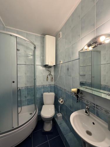 a bathroom with a toilet and a sink and a shower at Guest House Danver in Yaremche