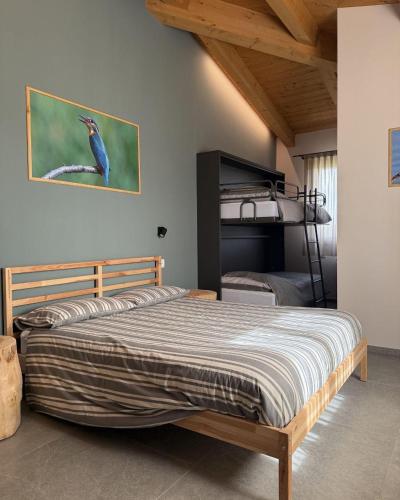 a bedroom with a bed with a bird picture on the wall at Agriturismo Ca' Belluccio in Santa Maria del Piano