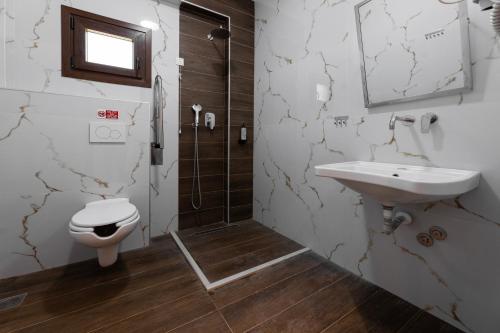 a bathroom with a toilet and a sink and a shower at Old Nikiti's Hotel in Nikiti