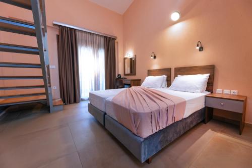 a bedroom with a large bed and a staircase at Old Nikiti's Hotel in Nikiti