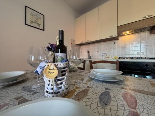 a bottle of wine sitting on a table with glasses at Residence Corallo con piscina in Rosolina Mare