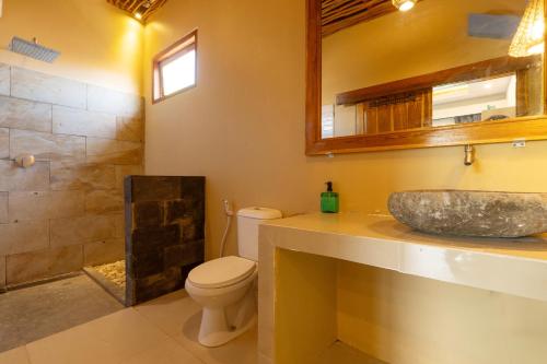 a bathroom with a sink and a toilet and a shower at Heyho Bungalow in Maluk