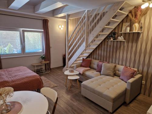 a living room with a couch and a staircase at Apartmán Sophia 6 in Velké Losiny