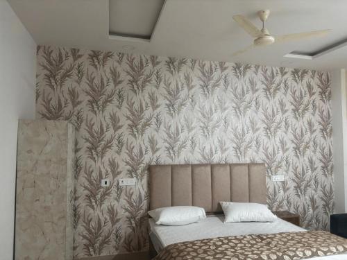 a bedroom with a bed and a wall with a wallpaper at The Royal Vintage Resort in Majhola