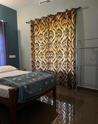 a bedroom with a curtain and a bed with a bench at Grass root by shelters in Vayittiri