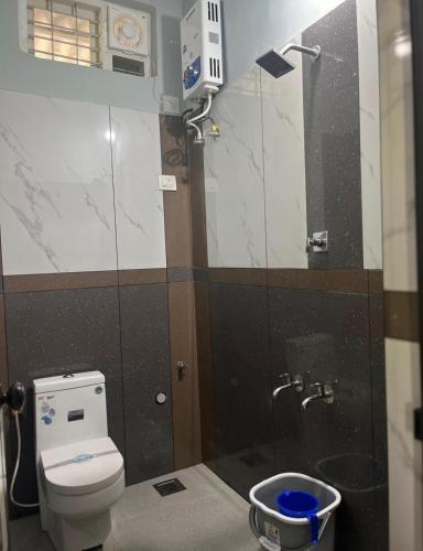 a bathroom with a toilet and a shower with a mirror at Grass root by shelters in Vayittiri