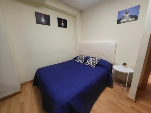 a small bedroom with a blue bed and a table at Arroyo in Coreses