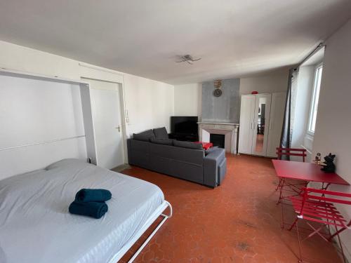 a living room with a bed and a couch at studio idealement situé in Marseille