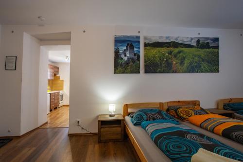 a bedroom with a couch and two paintings on the wall at U Moto Makovic in Horažďovice