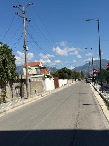 an empty street with a stop sign on the road at Airport Double Room in Kamëz