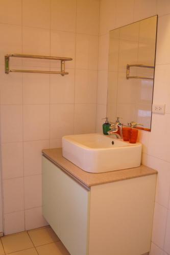 a bathroom with a white sink and a mirror at Trip GG Hostel in Kaohsiung