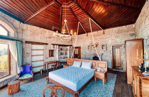 a bedroom with a bed and a table and chairs at Assos Dionysos Special Class Hotel Adults Only 12 years in Behramkale