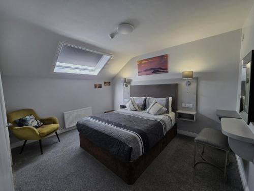 a bedroom with a bed and a chair in it at Murphy's Guesthouse in Dingle