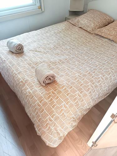 a bed with two towels on top of it at Escale en Provence in Carqueiranne