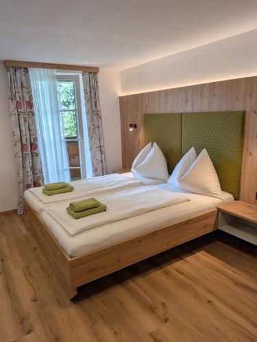 a large bed in a room with a large window at Pension Holzapfel in Sankt Georgen im Attergau