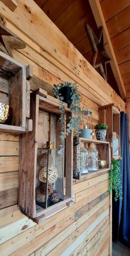 a wooden wall with shelves with bowls and vases at Le Masdemoiselle Chalet in Salernes