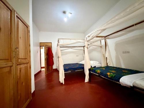 a bedroom with a bed with a canopy at Karibu Burudika Lodge in Bagamoyo