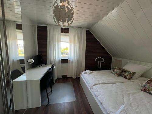a bedroom with a desk and a bed in a attic at Aluxhaus in Heidenau
