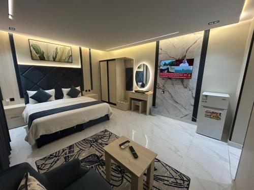 a bedroom with a king sized bed and a tv at شقق فاخرة in Riyadh