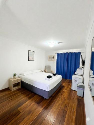 a bedroom with a large bed and a blue curtain at Ocean View Villas in Geraldton