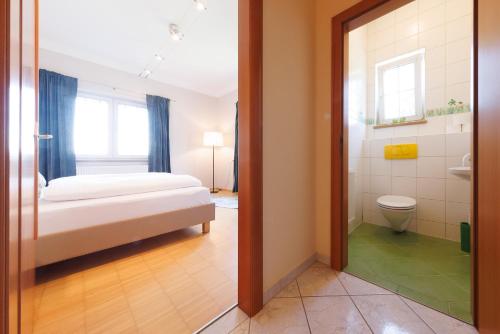 a bedroom with a bed and a bathroom with a toilet at Hotel Wachau in Melk