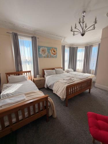 a bedroom with two beds and a chandelier at The Avenue GuestHouse in Newcastle upon Tyne