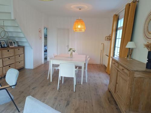 a dining room with a white table and chairs at Maison des bois in Neufchâtel-Hardelot