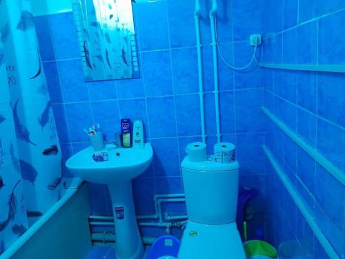 a blue bathroom with a toilet and a sink at UYUT INN apartment in Samarkand