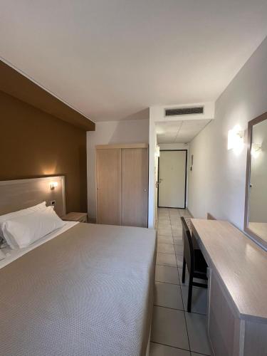 a hotel room with a bed and a desk at Hotel Bulla Regia in Fontane Bianche
