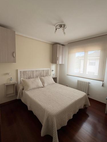 a bedroom with a bed with a white bedspread and a window at Saron Centro in Sarón