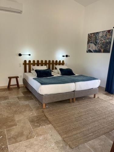 a bedroom with a large bed with two pillows at Les maisons de loup a loup in Cotignac