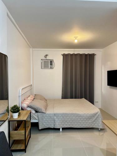 a small bedroom with a bed and a tv at Sebastians CRIB D in Dasmariñas