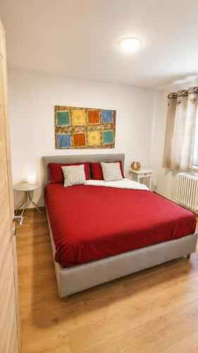 a bedroom with a large bed with a red blanket at Verde Betulla, Free Park and Ski room in Camporosso in Valcanale