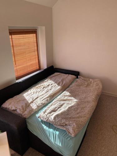 a bedroom with a bed with a blanket on it at 40 kvm lejlighed in Kjellerup