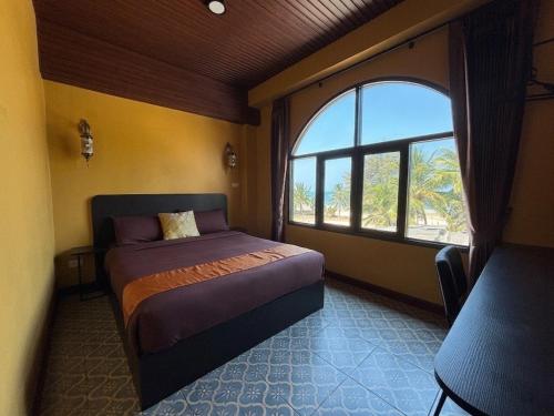 a bedroom with a bed and a large window at Phoenix Room in Ban Tha Samet (1)