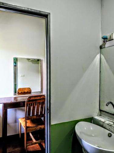 a bathroom with a sink and a mirror and a chair at Lake view house in Ko Phangan