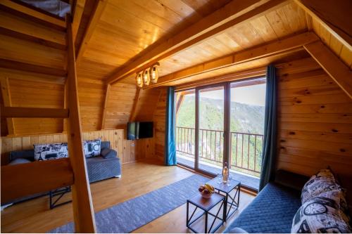a room with a large window in a log cabin at Rural Resort Tron Gold in Plužine