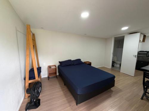 a bedroom with a blue bed and a wooden ladder at Casa de campo em meio a natureza in Araras Petropolis