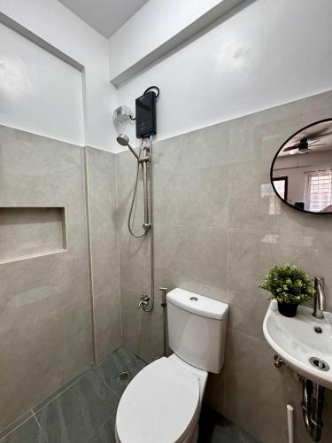 a bathroom with a shower and a toilet and a sink at Sebastians CRIB D in Dasmariñas