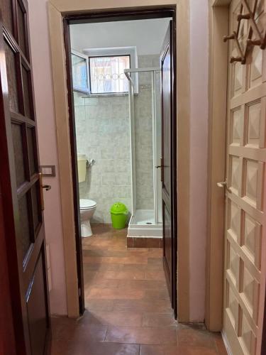 ein Badezimmer mit Dusche, Toilette und Tür in der Unterkunft Clio 21 in Marina di Massa