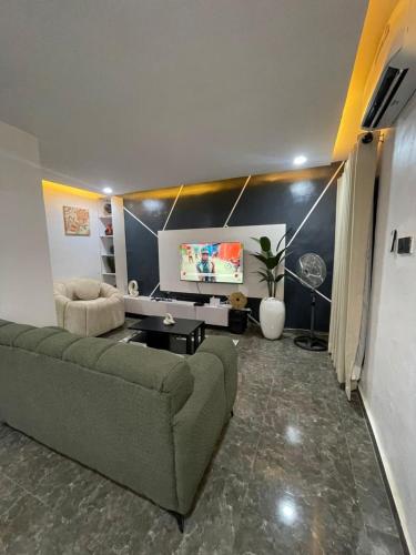 a living room with a couch and a flat screen tv at Kayus Place in Isaga-Abosule