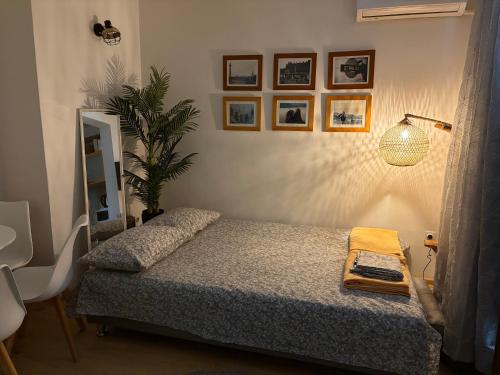 a bedroom with a bed and a lamp and pictures on the wall at Apartman Biljana in Rafailovici