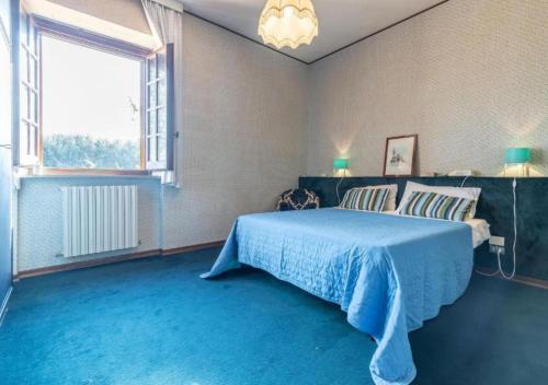 a bedroom with a blue bed and a large window at Villa Krizia - Ancona, meravigliosa villa con piscina vista mare in Ancona