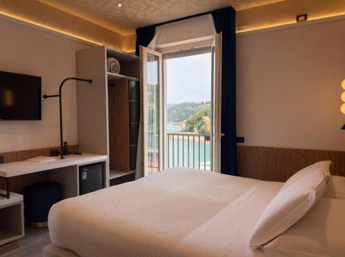 a bedroom with a bed and a large window at Hotel Florida Lerici in Lerici