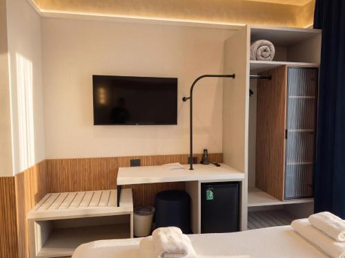 a room with a desk and a tv on a wall at Hotel Florida Lerici in Lerici