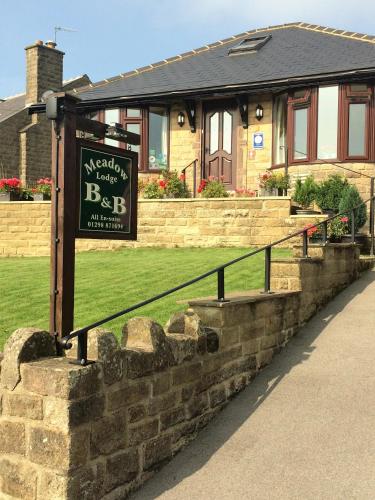 a sign in front of a house at Meadow Lodge in Tideswell