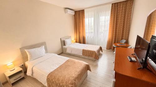 a hotel room with two beds and a flat screen tv at Hotel Sport B90 in Buzău