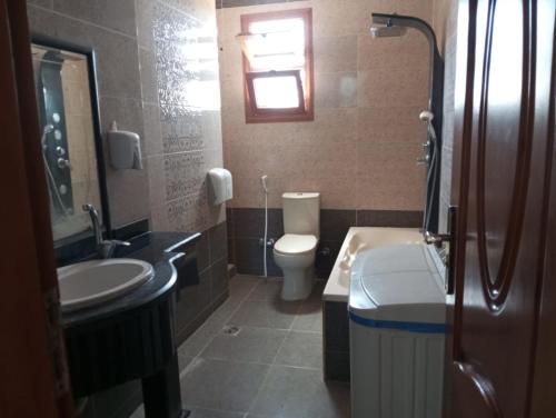 a bathroom with a sink and a toilet and a sink at Villa Layan الريف الاوروبي in Madīnat as Sādāt